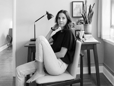 Portrait of the playwright Olivia Clement at her writing desk, in black and white