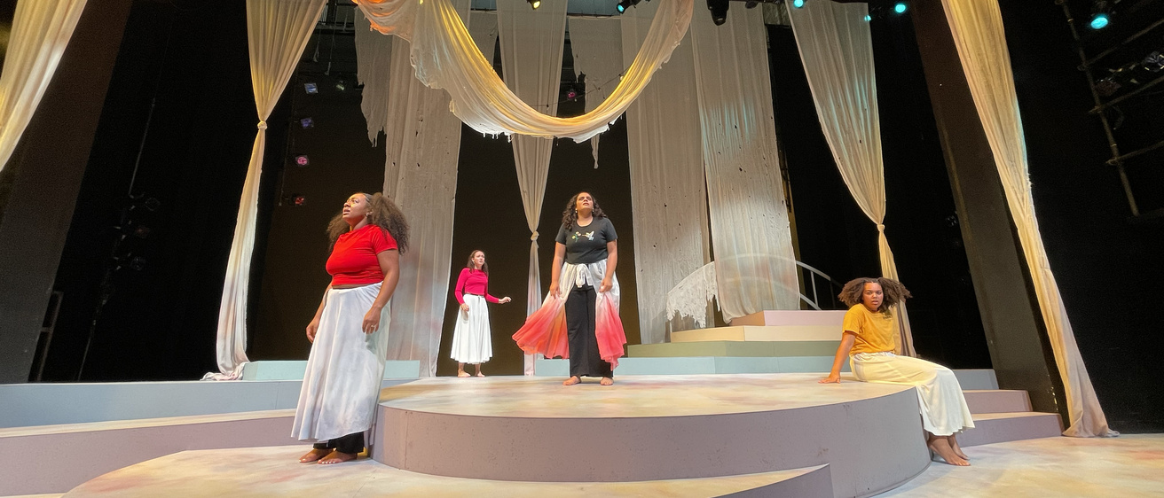 Cast of UI Theatre Arts' production of "for colored girls who have considered suicide / when the rainbow is enuf" on stage looking out into the audience